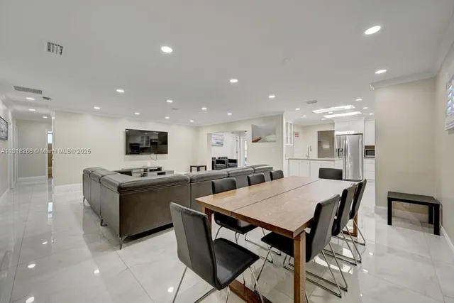 a large kitchen with kitchen island a sink table and chairs
