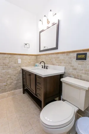 a bathroom with a toilet a sink a mirror and vanity