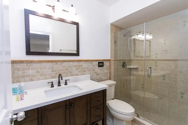 a bathroom with a toilet a sink a mirror and vanity