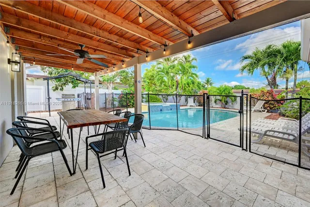 a view of a backyard with table and chairs under an umbrella with a small yard