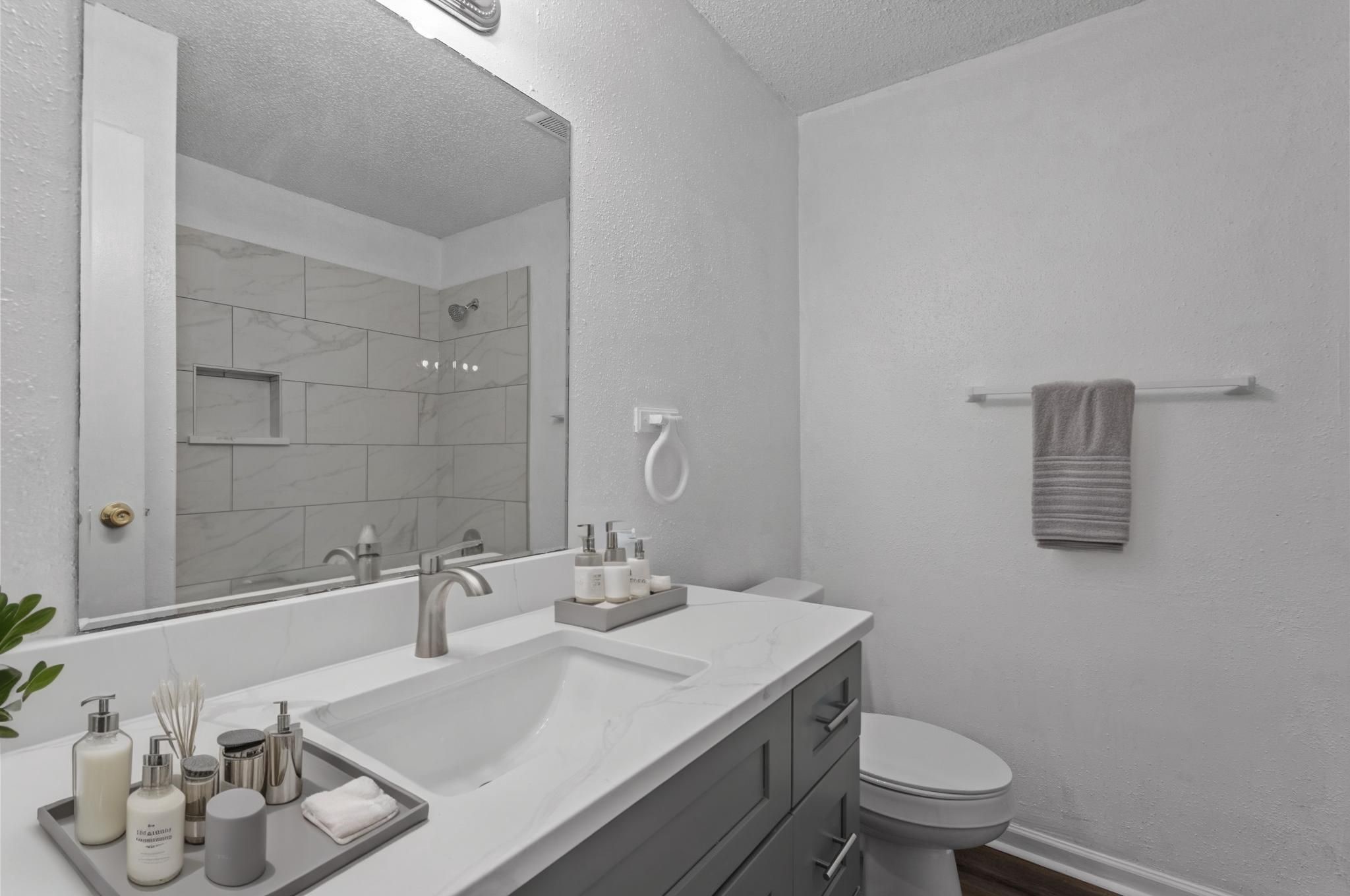 11002 Hammerly Boulevard, Unit 61 Houston, TX 77043 - Photo 4 of 12 a bathroom with a granite countertop sink a toilet and a mirror