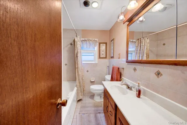 a bathroom with a sink a toilet and shower curtain