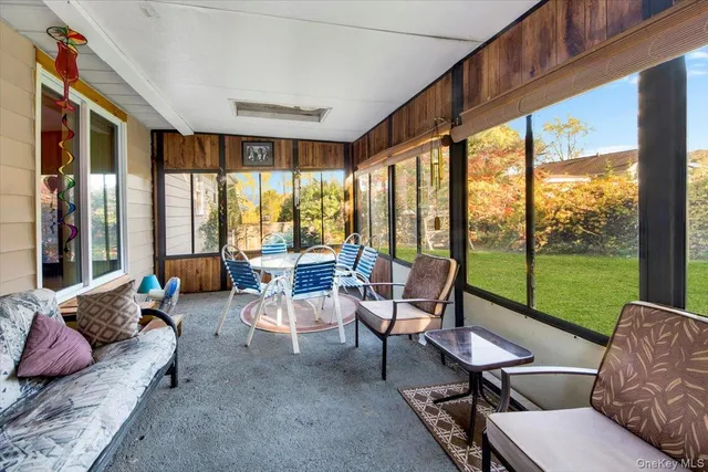 a living room with furniture and a floor to ceiling window