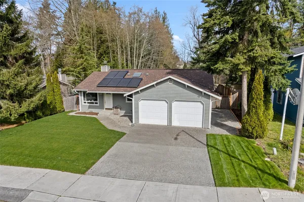 a front view of a house with a yard and trees