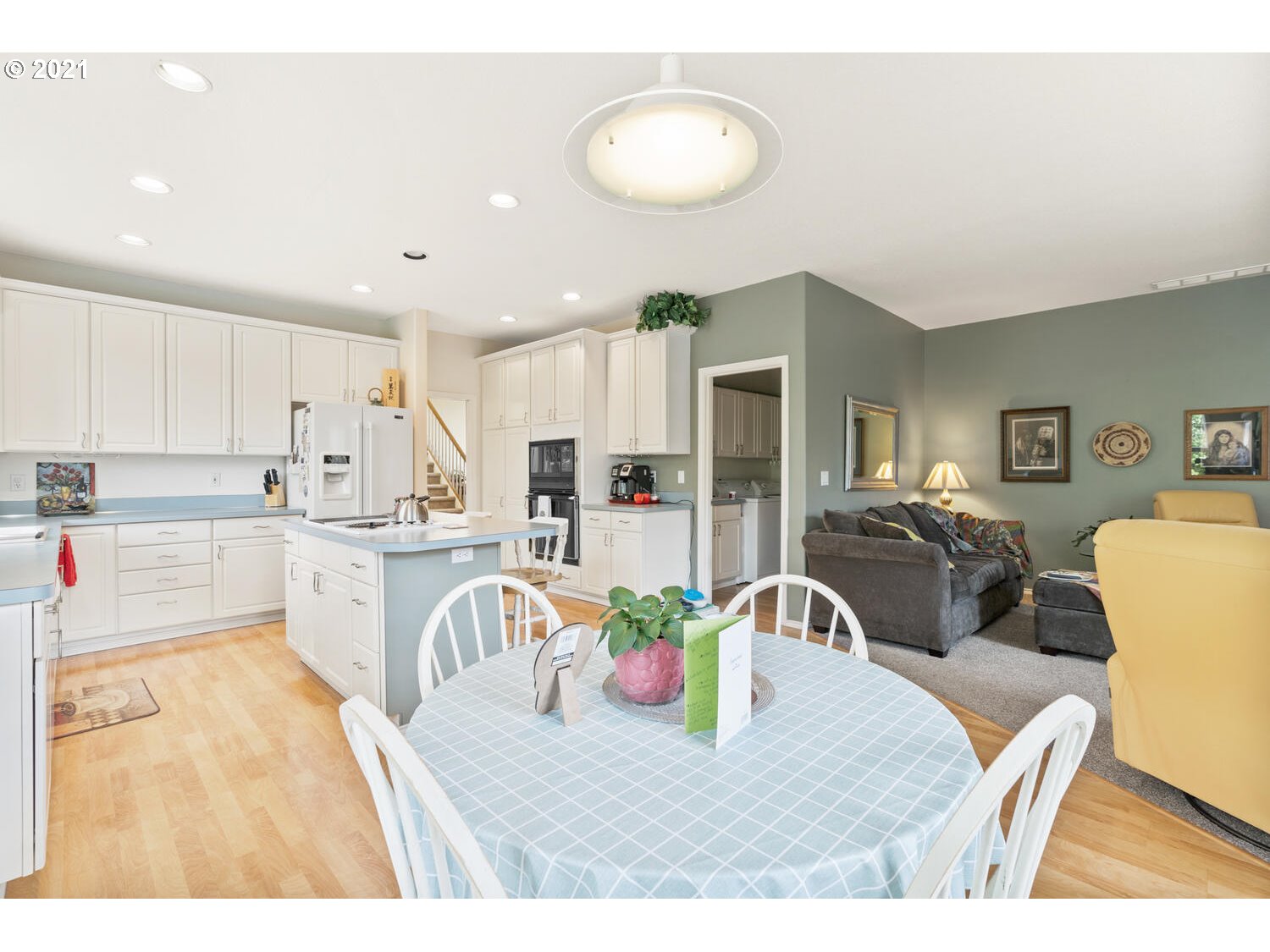 16980 Southwest Ferrelo Place Beaverton, OR 97007 - Photo 11 of 32 a kitchen with a table chairs refrigerator and microwave