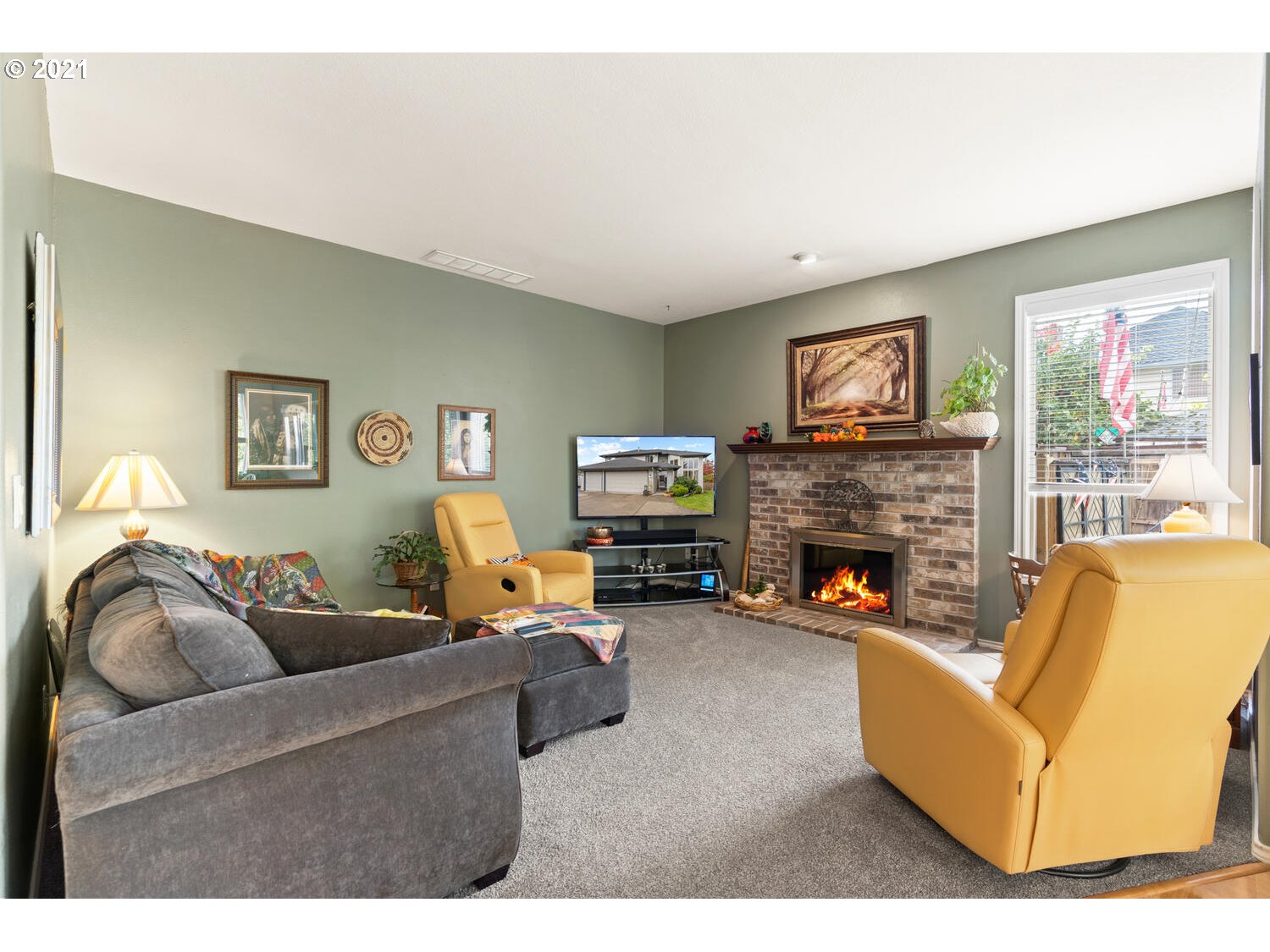 16980 Southwest Ferrelo Place Beaverton, OR 97007 - Photo 14 of 32 a living room with furniture a flat screen tv and a fireplace