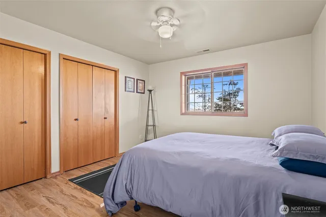a bedroom with a bed and wooden floor