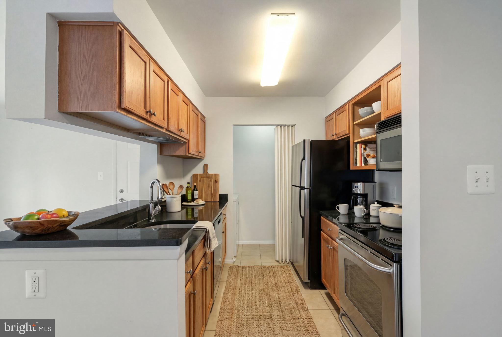 11703 Olde English Drive, Unit B Reston, VA 20190 - Photo 12 of 32 a kitchen with stainless steel appliances granite countertop a refrigerator and a stove top oven
