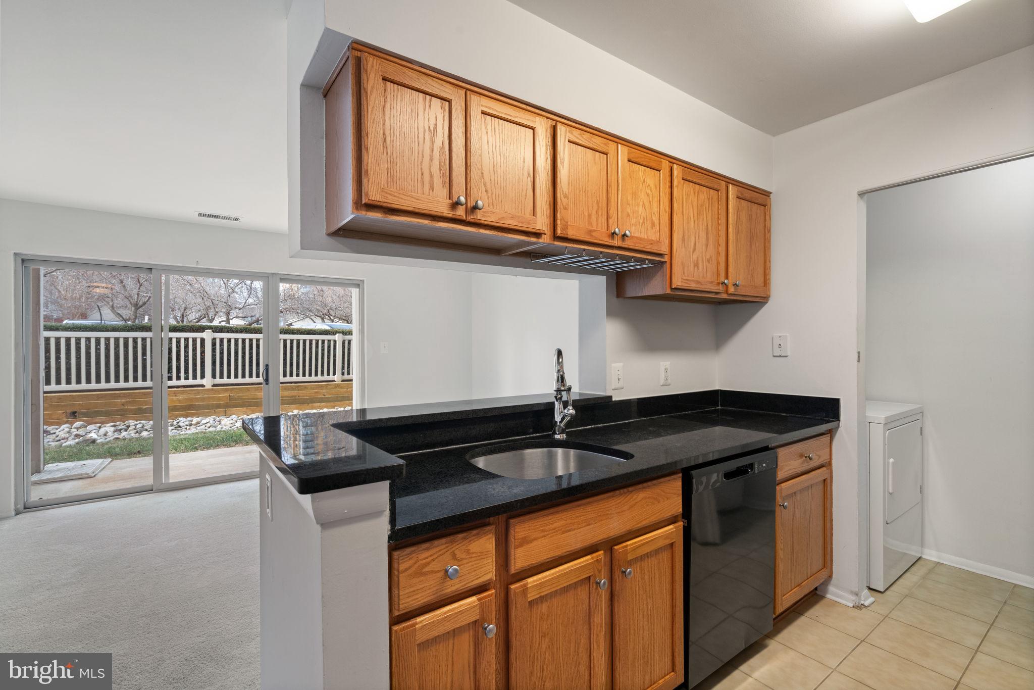 11703 Olde English Drive, Unit B Reston, VA 20190 - Photo 14 of 32 a kitchen with granite countertop a sink and cabinets