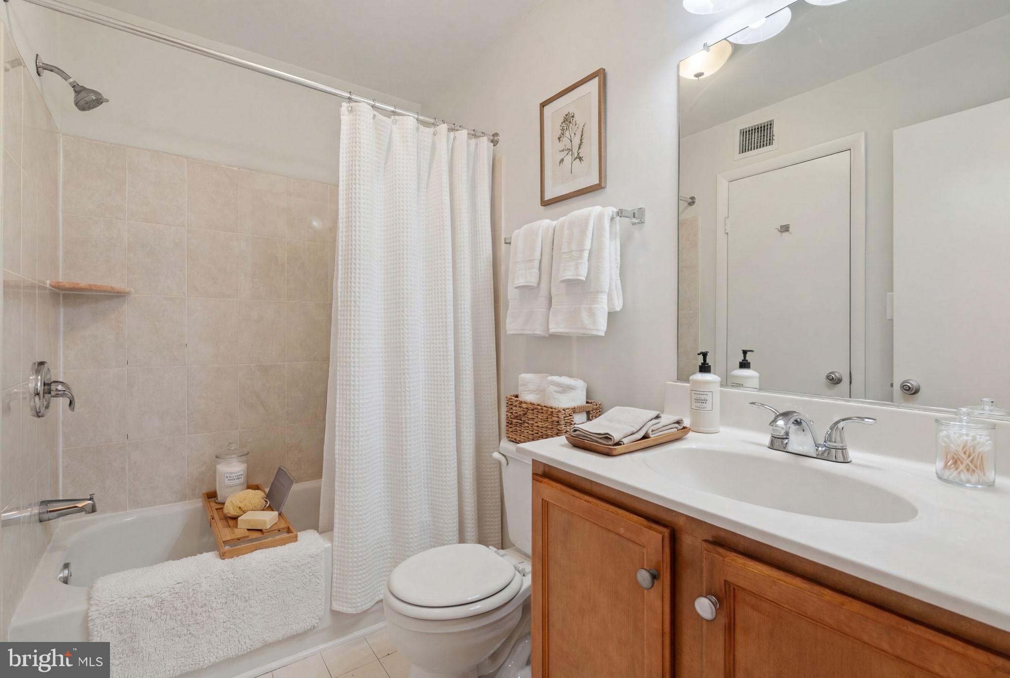 11703 Olde English Drive, Unit B Reston, VA 20190 - Photo 27 of 32 a bathroom with a granite countertop sink mirror vanity and toilet