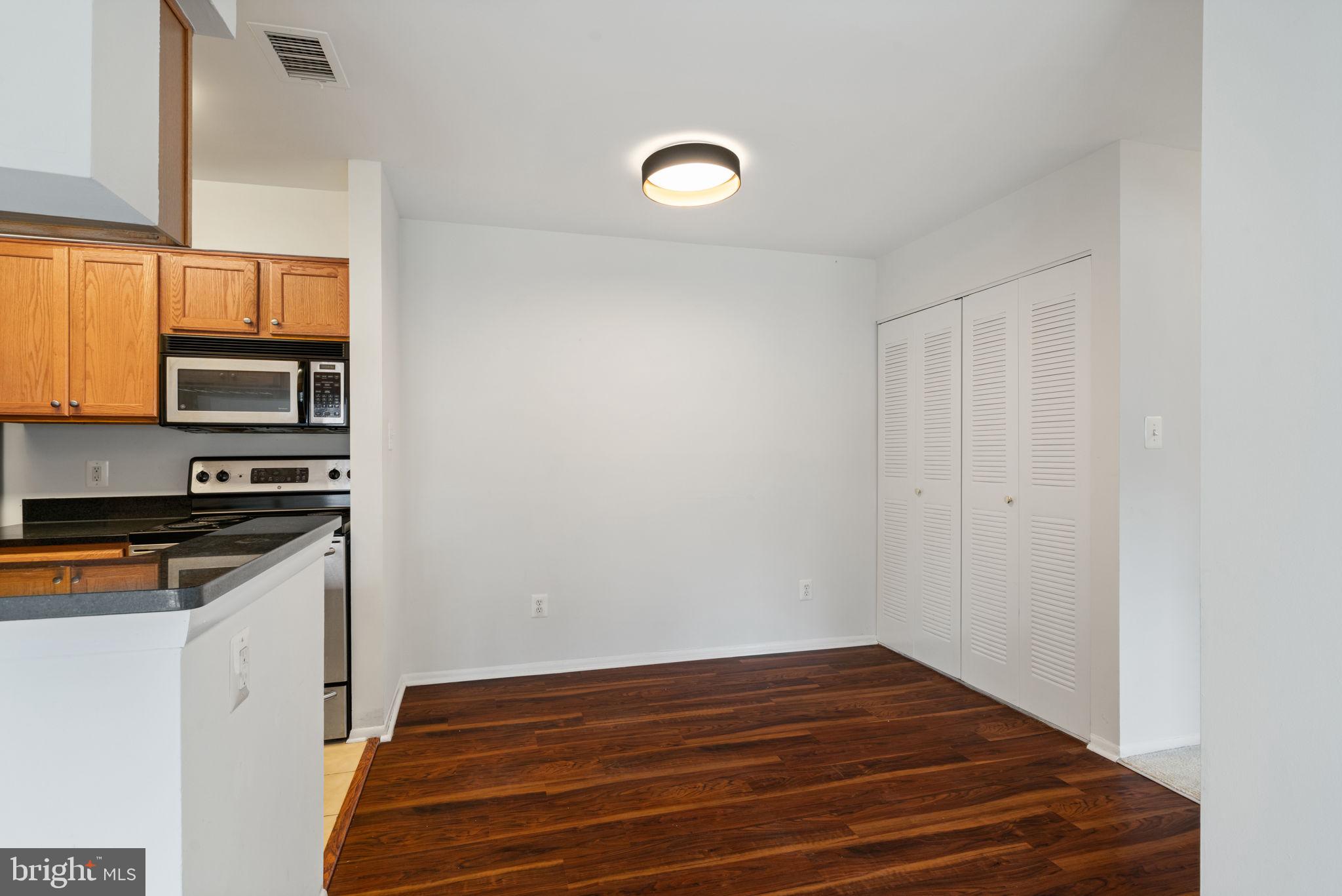 11703 Olde English Drive, Unit B Reston, VA 20190 - Photo 9 of 32 a view of a kitchen with wooden floor and electronic appliances