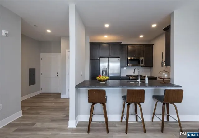 a kitchen with refrigerator and chairs