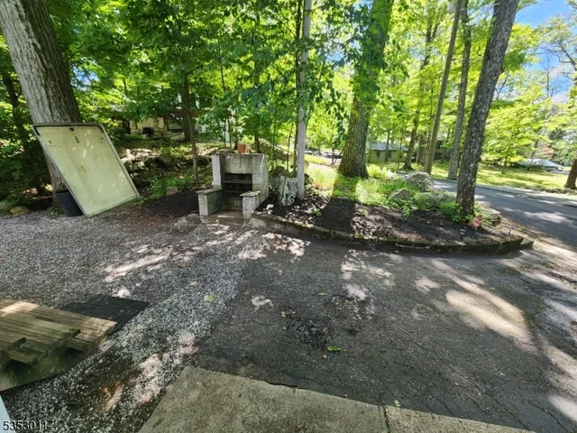 a backyard of a house with large trees and outdoor seating