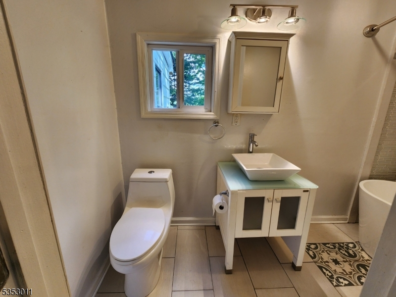 7 Raccoon Island Road Lake Hopatcong, NJ 07849 - Photo 8 of 24 a bathroom with a toilet a sink a mirror and a window