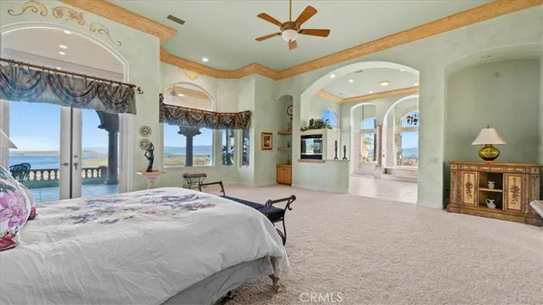 a view of swimming pool with outdoor seating and trees in the background
