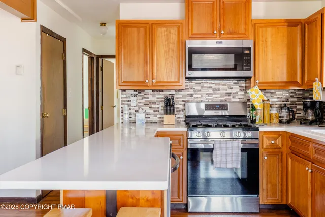 a kitchen with stainless steel appliances granite countertop a stove a sink and a microwave