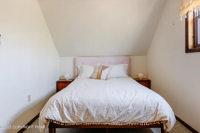 a bed sitting in a bedroom next to a window