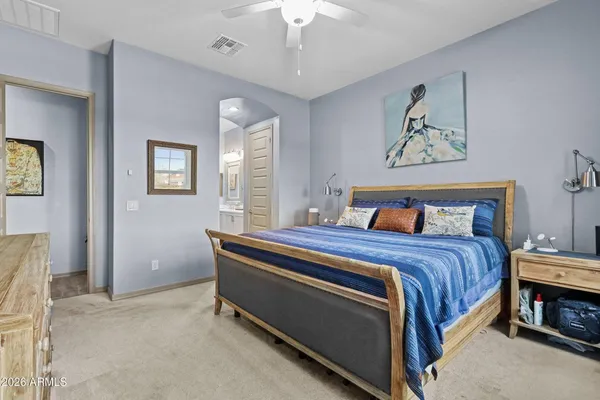 a bedroom with bed and paintings on the wall