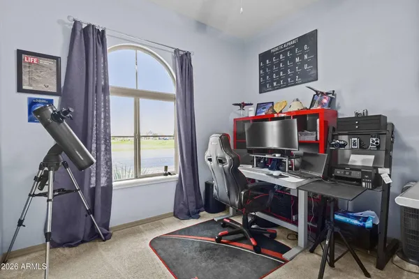 a view of a workspace with furniture and a window