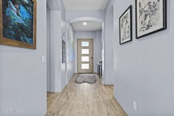 a view of a hallway with wooden floor and a bathroom