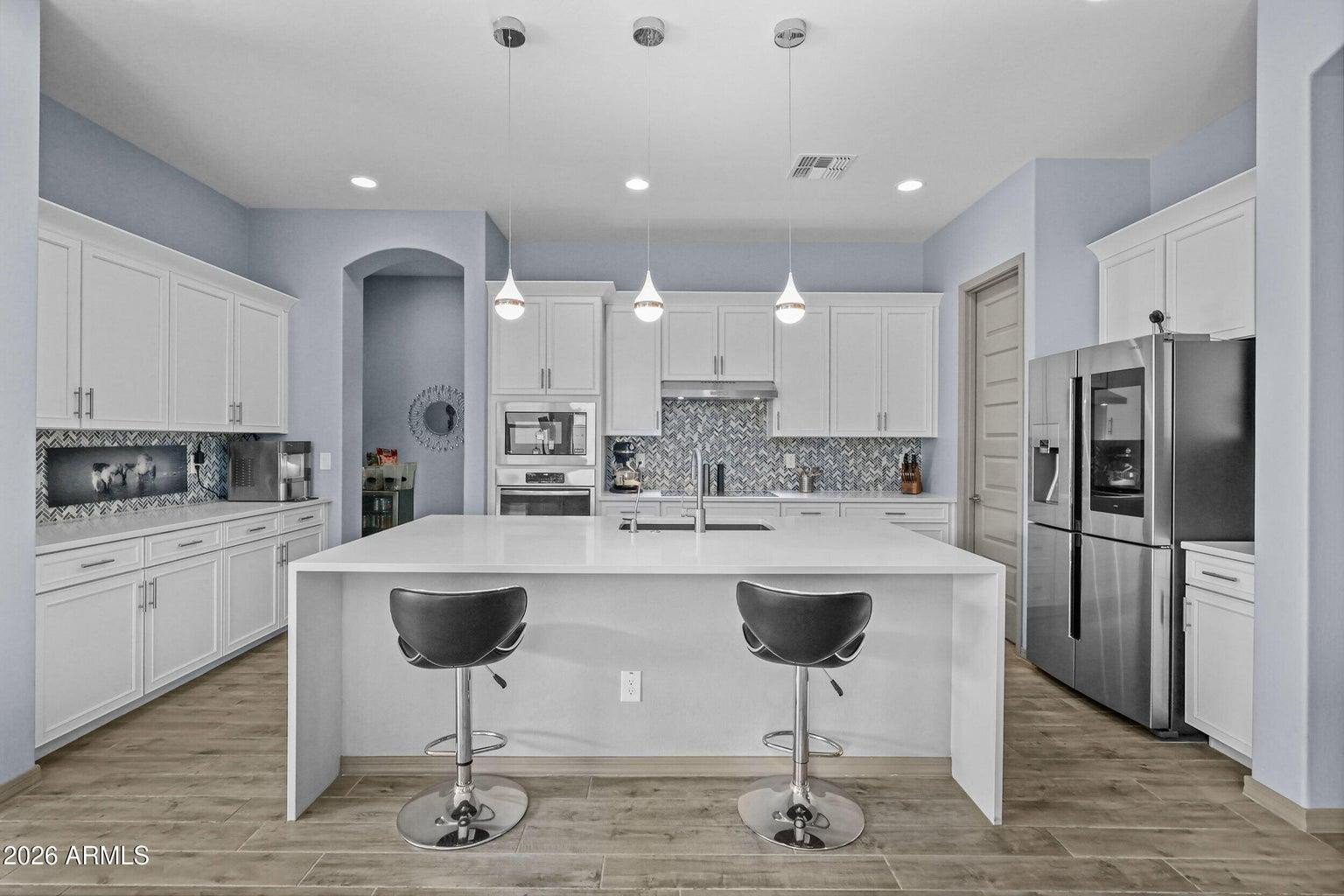 4451 East Bernice Street Gilbert, AZ 85295 - Photo 5 of 32 a kitchen with kitchen island a appliances a counter space and a dining table
