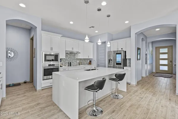 a kitchen with stainless steel appliances kitchen island granite countertop a refrigerator and a stove top oven