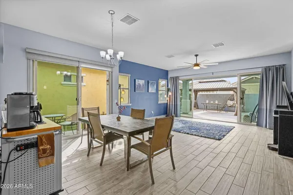 a dining room with furniture a chandelier and wooden floor