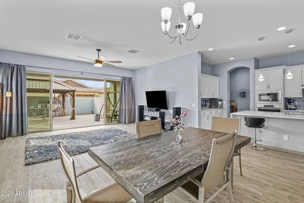 a view of a dining room with furniture a chandelier and wooden floor