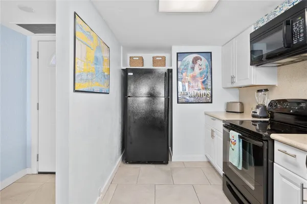 a kitchen with white cabinets and sink
