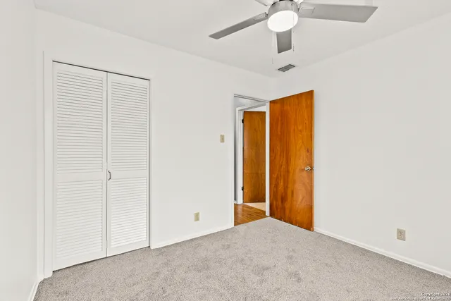 an empty room with chandelier fan