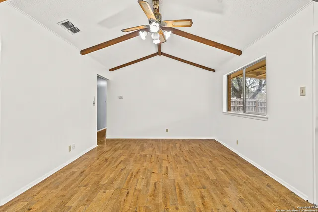 a view of a big room with wooden floor and a ceiling fan
