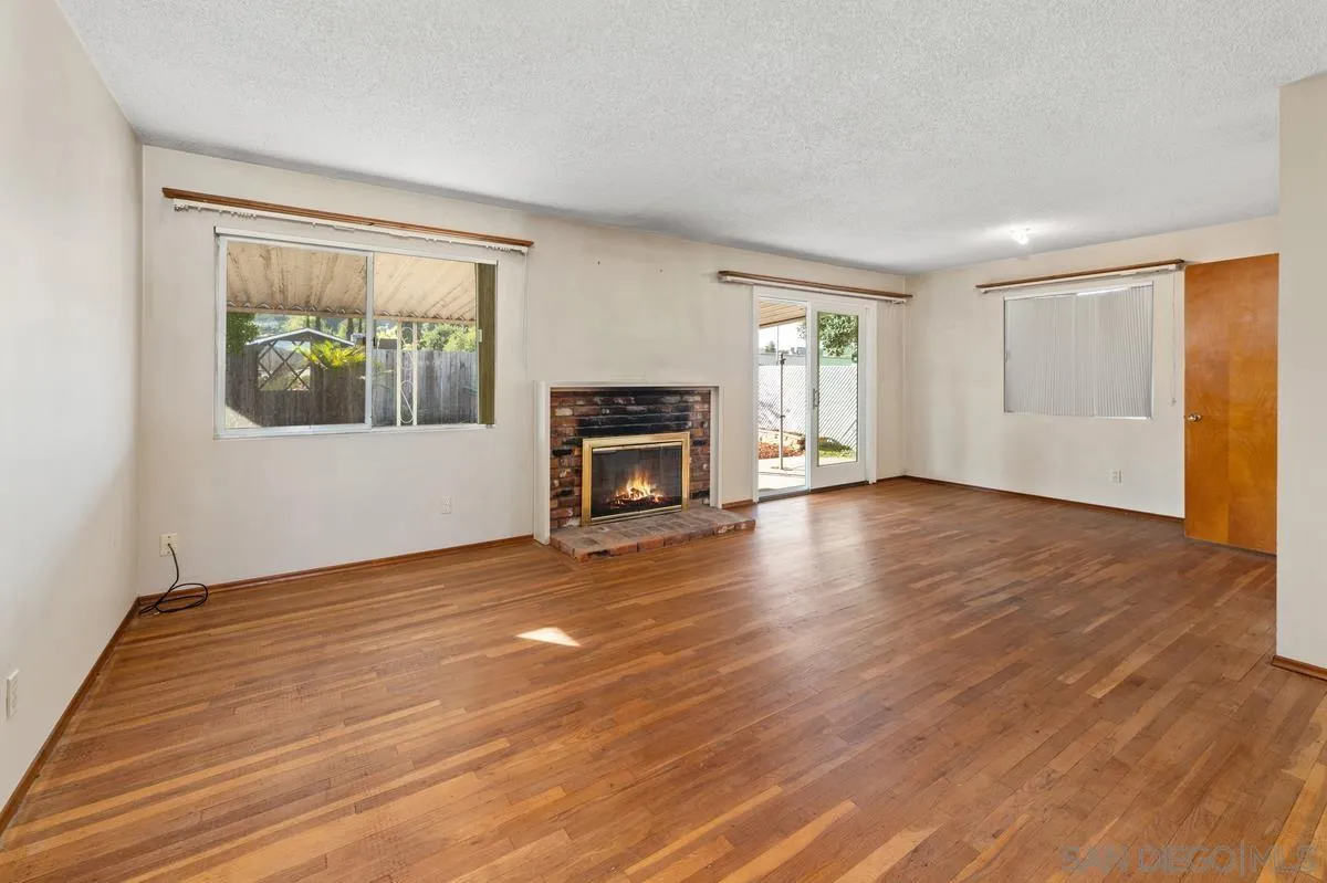 1119 Buckskin Road El Cajon, CA 92019 - Photo 6 of 27 an empty room with wooden floor fireplace and windows