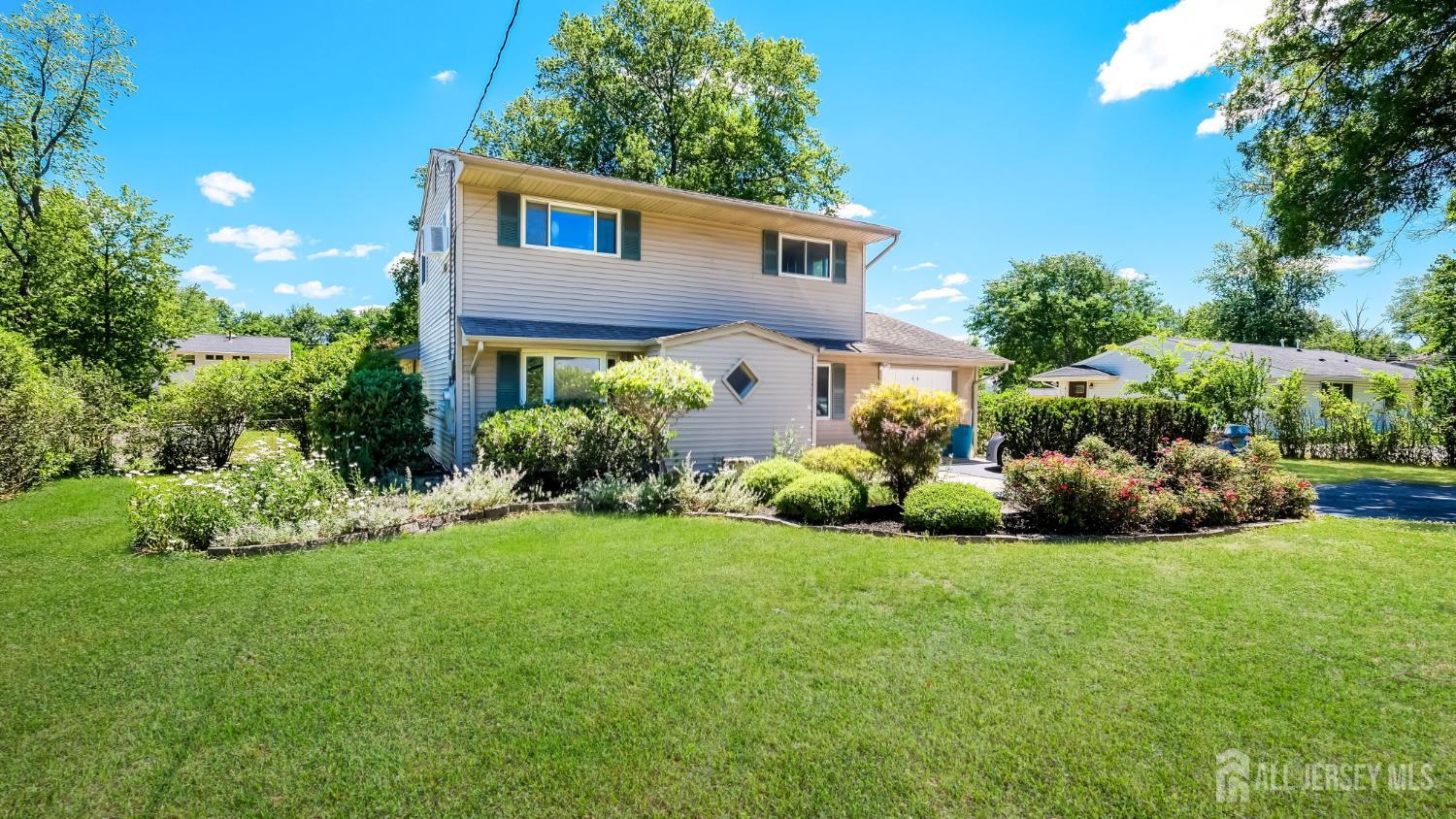 50 Sand Hills Road Kendall Park, NJ 08824 - Photo 26 of 27 a front view of a house with a garden and plants