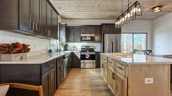 a kitchen with stainless steel appliances granite countertop a sink a stove and a refrigerator