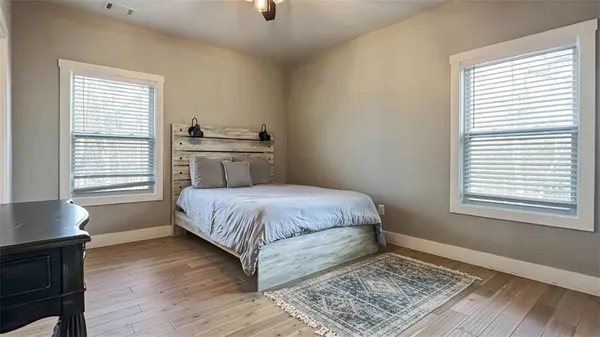 a bedroom with a bed and wooden floor