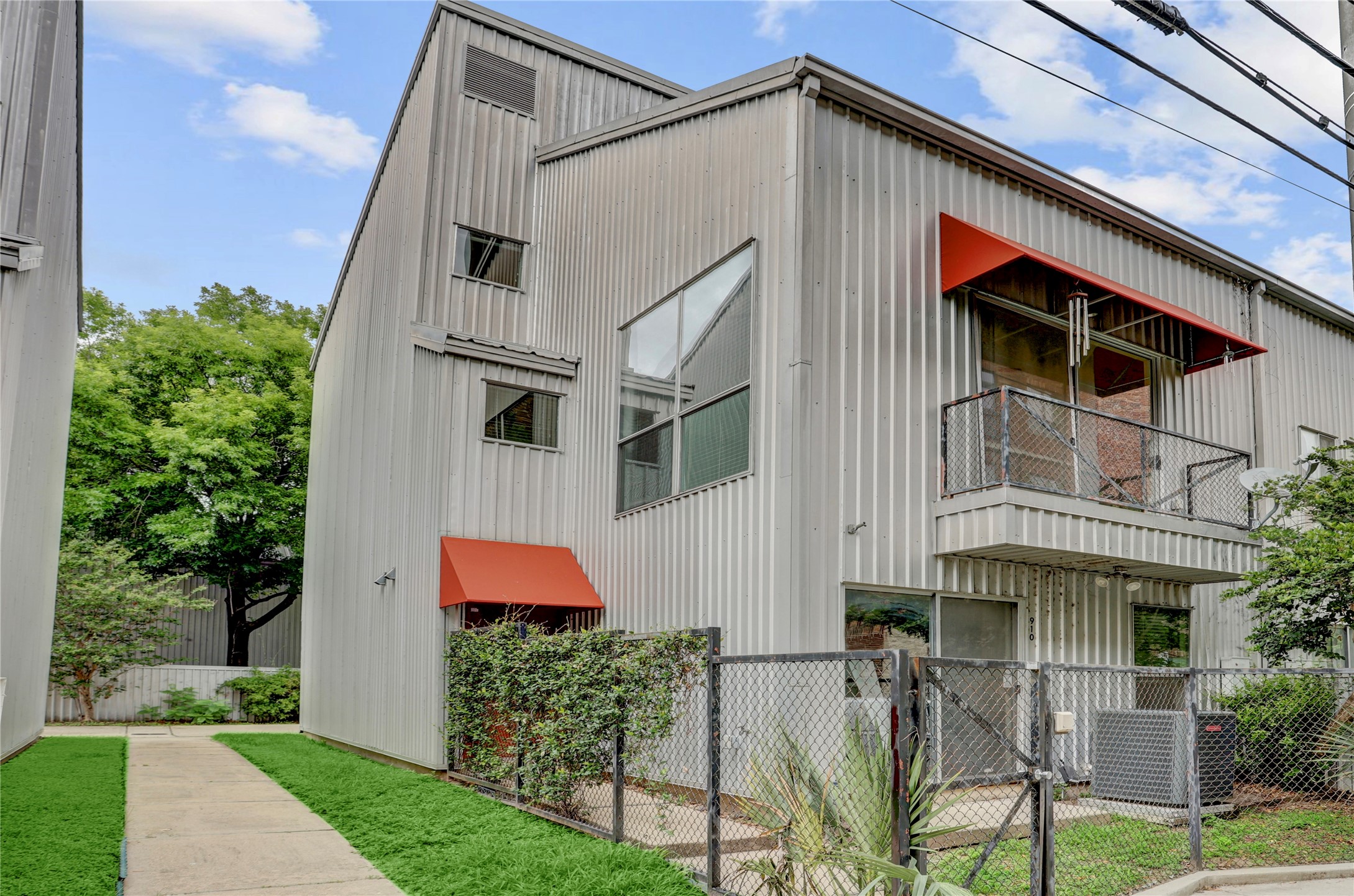 910 Ruthven Street Houston, TX 77019 - Photo 1 of 35 Front elevation on a quiet block and noticed the additional windows since it’s a corner unit. Privacy fence in front and sliding doors and balcony above.