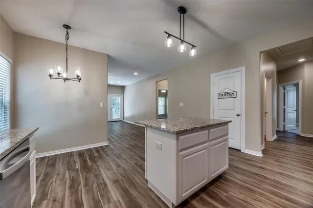 a kitchen with a stove and wooden floor