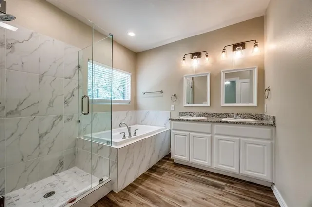 a spacious bathroom with a double vanity sink a mirror and a bathtub