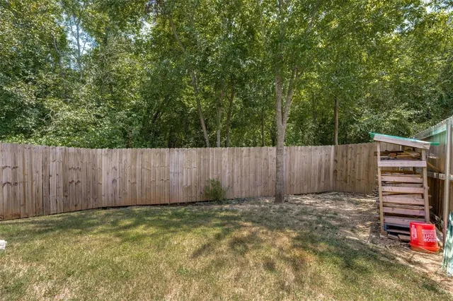 a view of a backyard with wooden fence