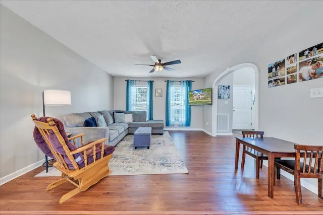 a living room with furniture a wooden floor and a chandelier