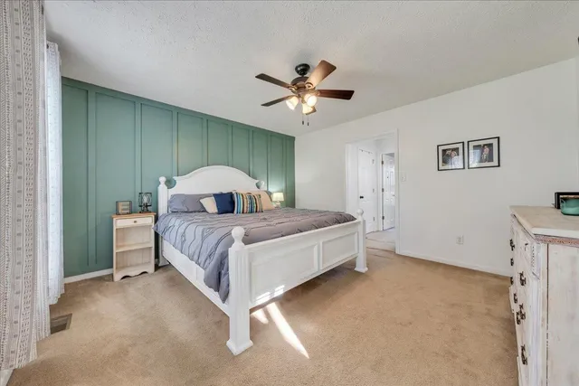 a bedroom with a bed and a ceiling fan