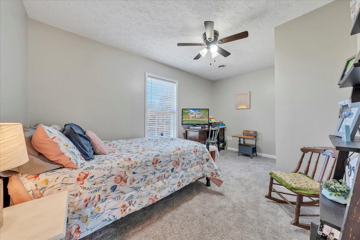 780 Farmington Road Hardy, VA 24101 - Photo 31 of 50 a bedroom with a bed a couch and a chandelier