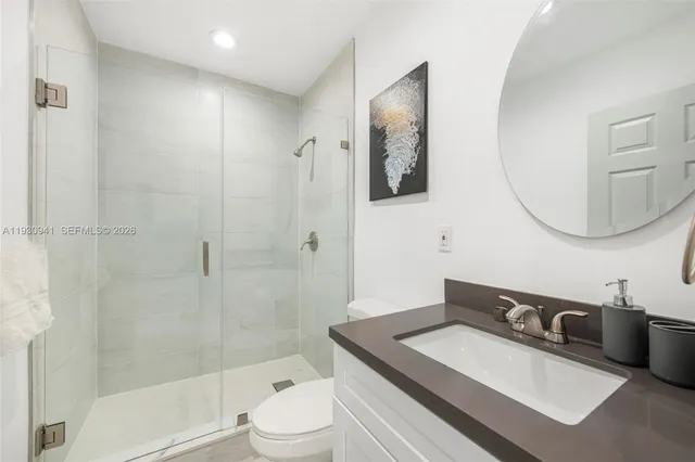 a bathroom with a sink a toilet and shower