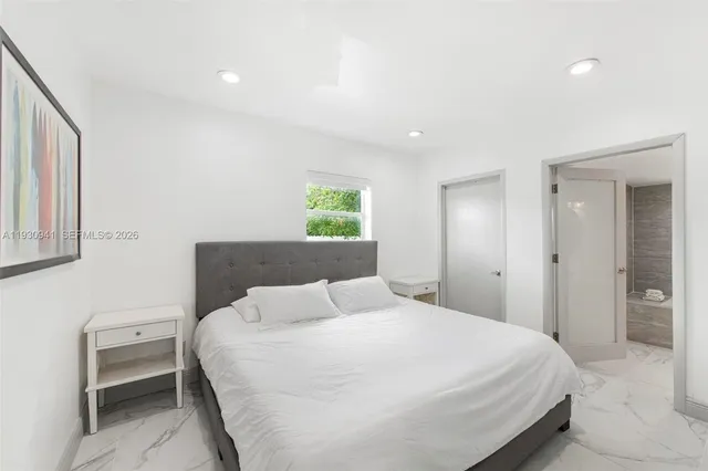 a bedroom with a bed a lamp and a large window