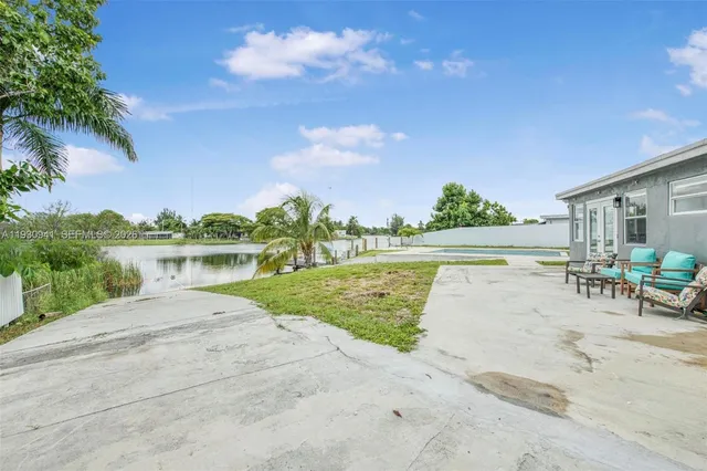 a view of a lake with a yard and a large tree