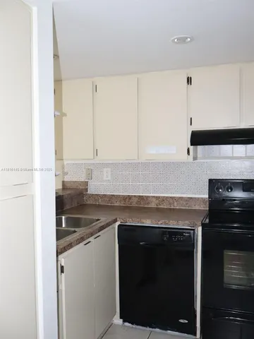 a kitchen with granite countertop a stove and a sink