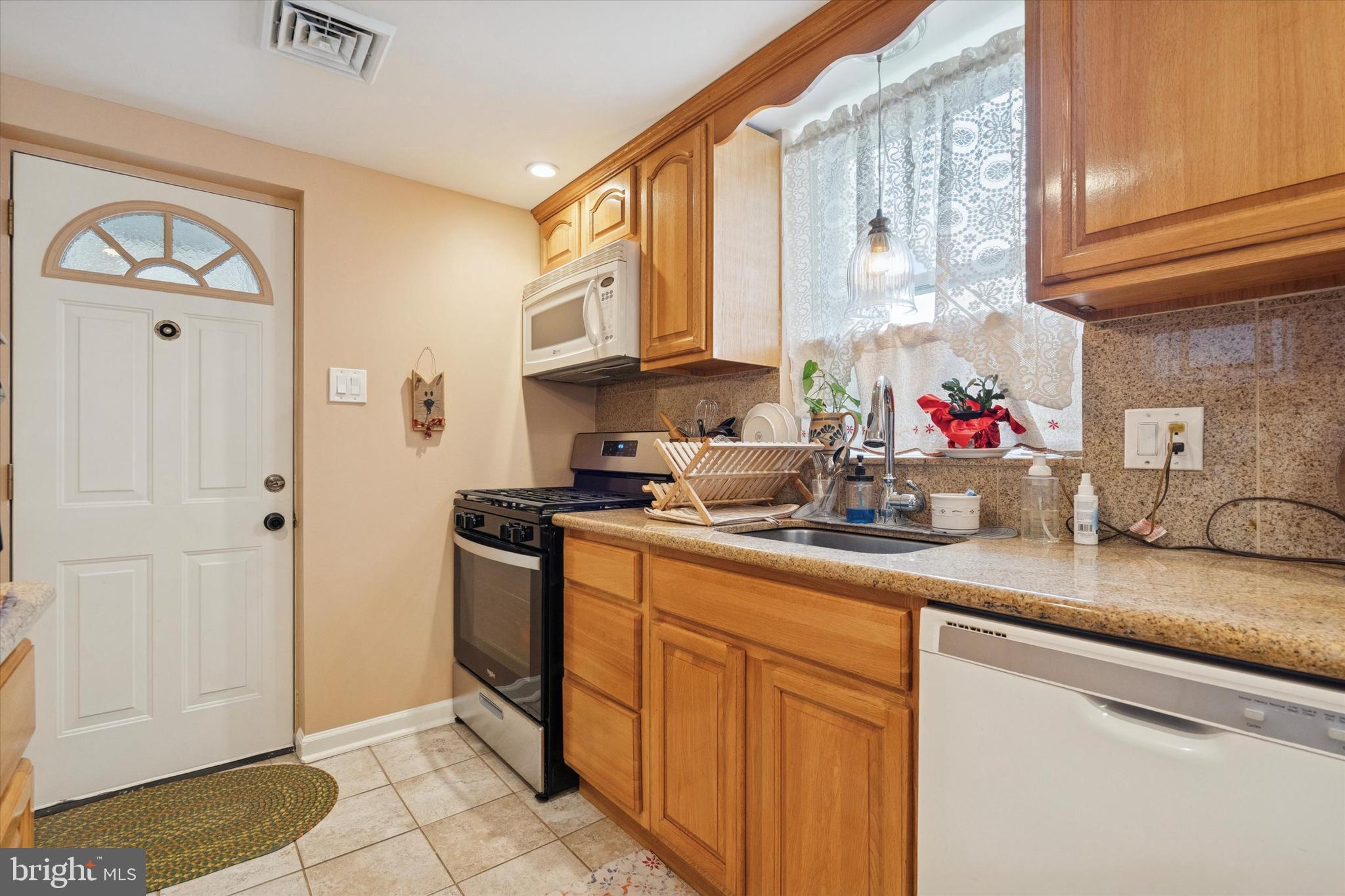 9208 Exeter Road Philadelphia, PA 19114 - Photo 8 of 15 a kitchen with stainless steel appliances granite countertop a sink stove and cabinets