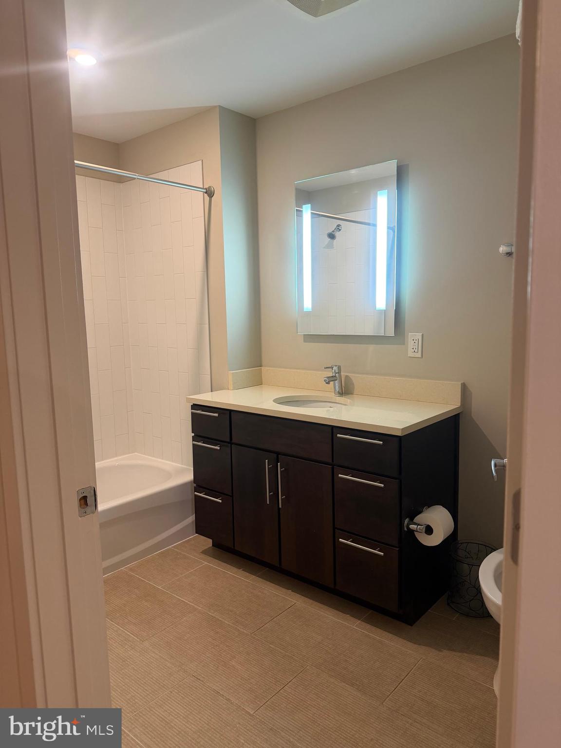 1320 Fenwick Lane, Unit 700 Silver Spring, MD 20910 - Photo 15 of 25 a bathroom with a tub sink vanity and a mirror