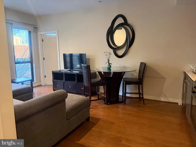 a living room with furniture a refrigerator and kitchen view