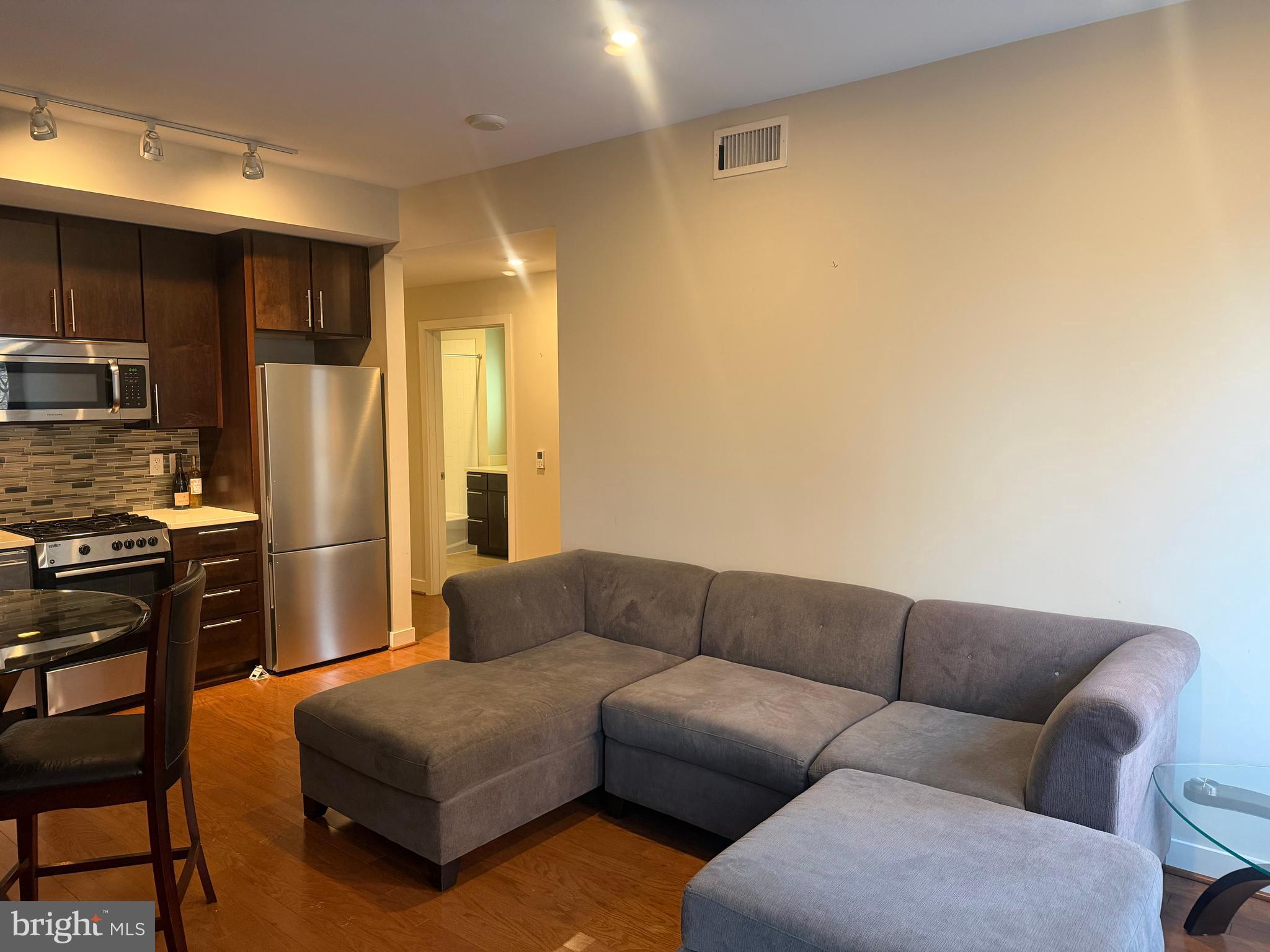 1320 Fenwick Lane, Unit 700 Silver Spring, MD 20910 - Photo 20 of 25 a living room with furniture a refrigerator and kitchen view